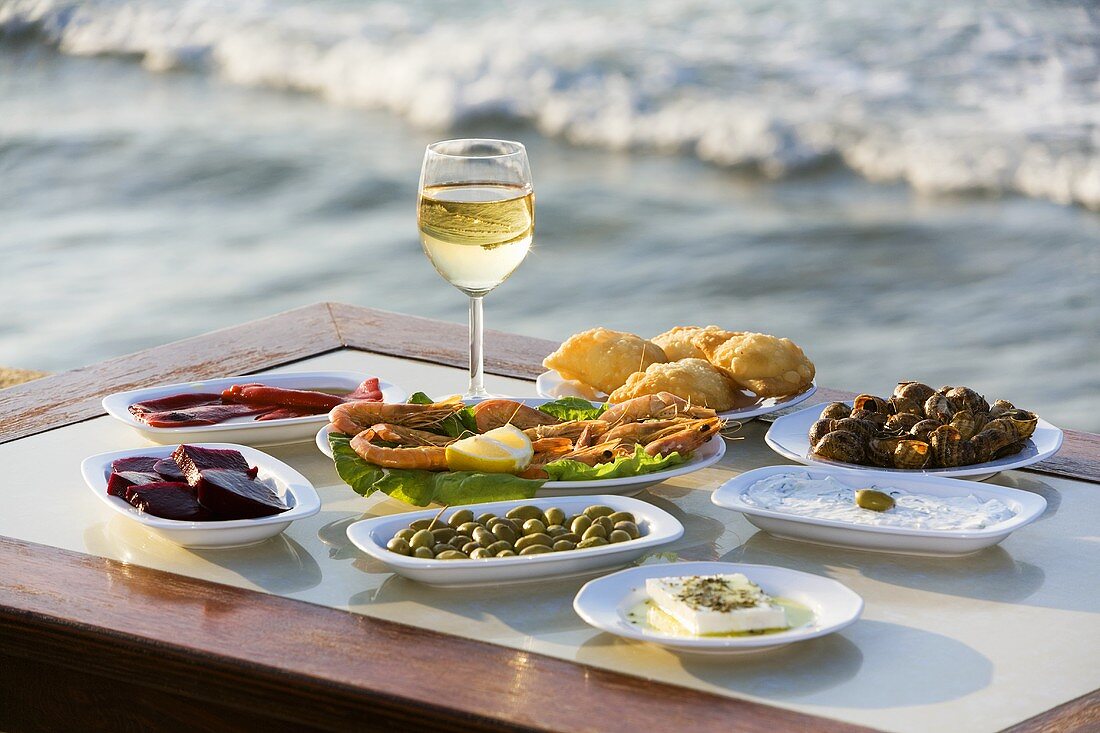 Assorted appetisers and white wine on the beach