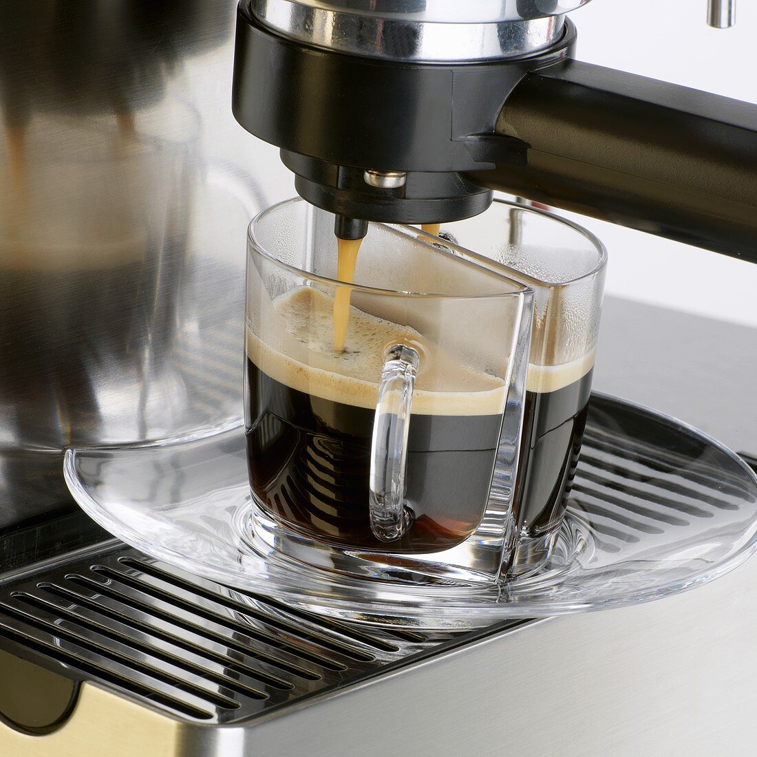 Espresso fließt in zwei Tassen
