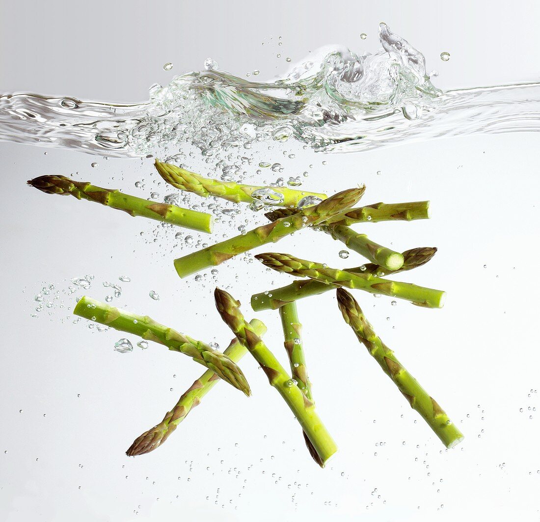 Green asparagus falling into water