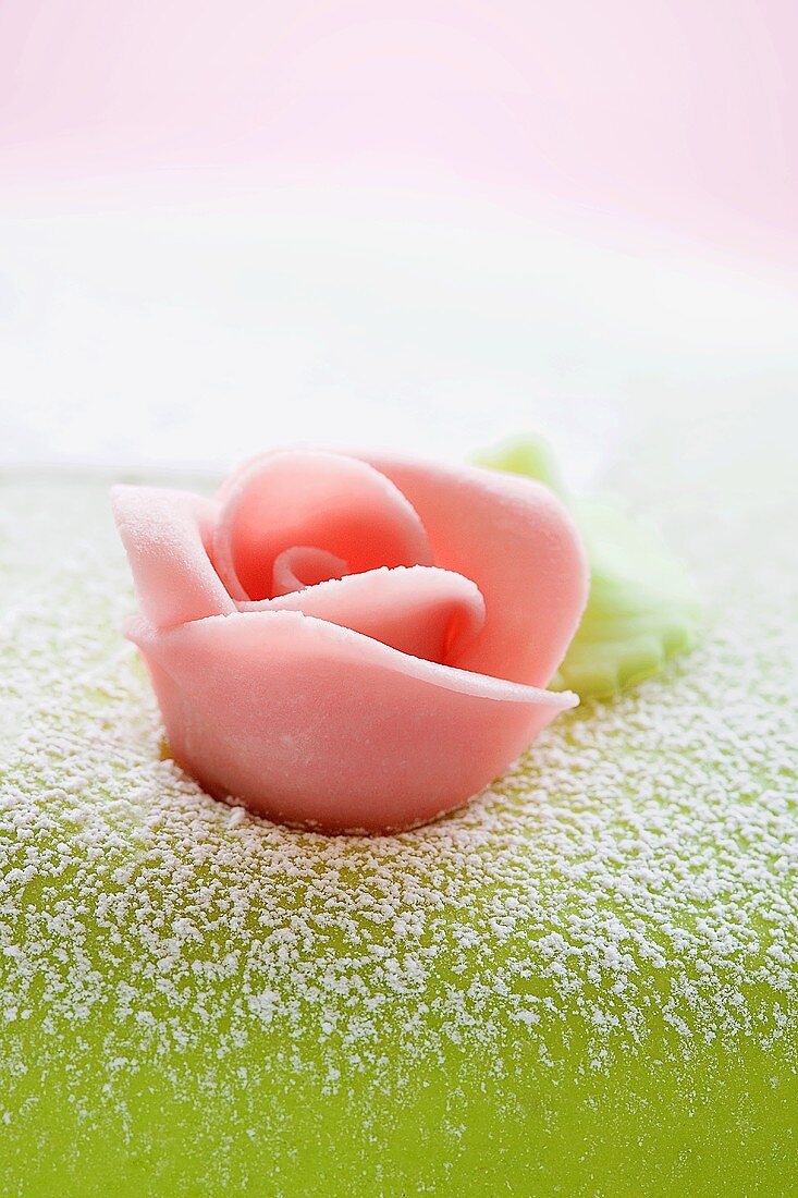 Eine rosa Marzipanrose als Kuchenverzierung