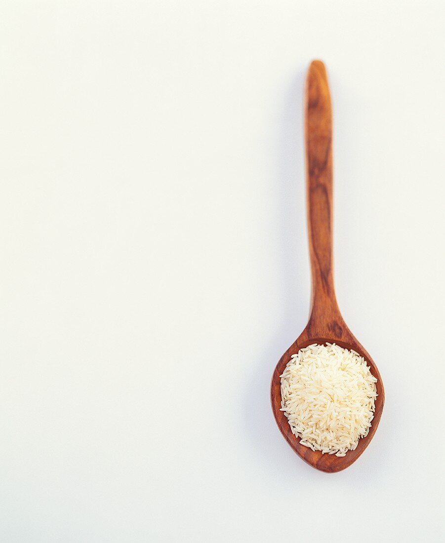 Uncooked fragrant rice on a wooden spoon