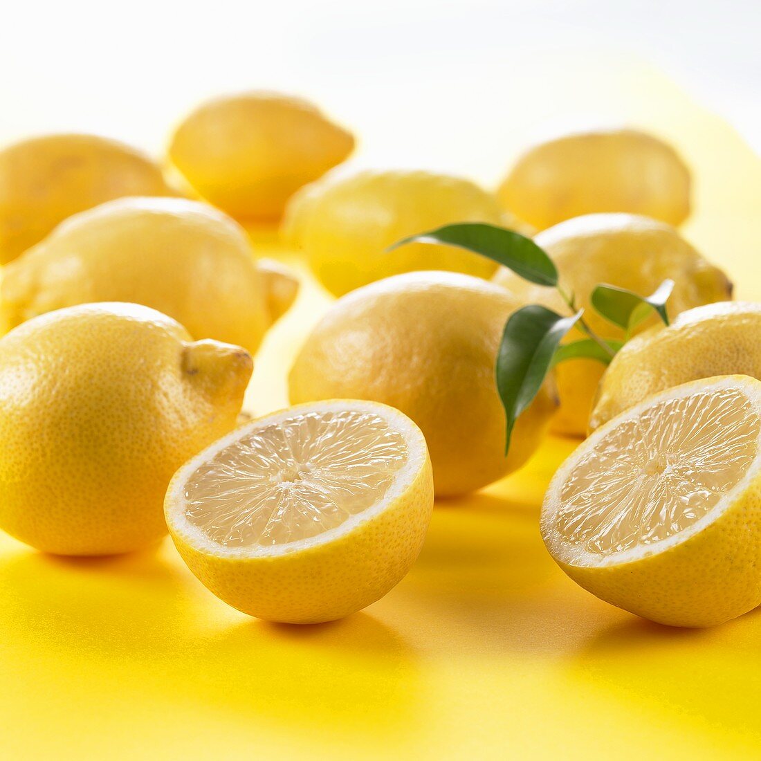 Eine halbierte und ganze Zitronen