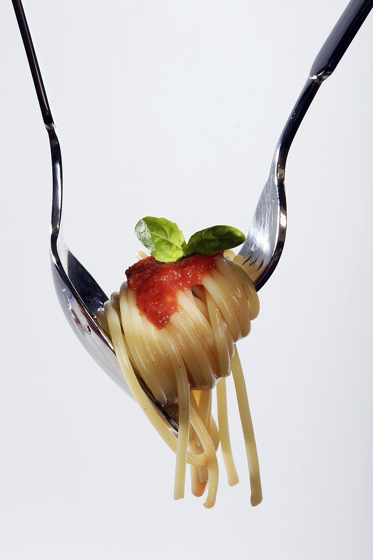 Spaghetti mit Tomatensauce auf Gabel und Löffel