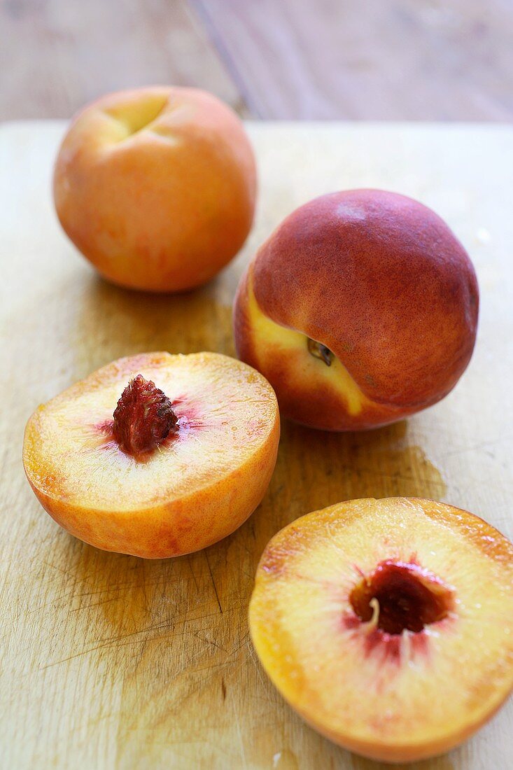 Two whole peaches and one halved peach