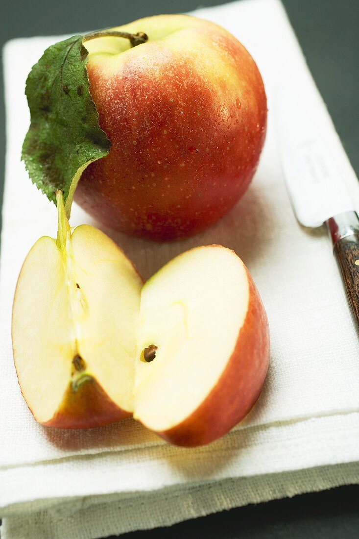 Elstar apples, whole and cut into pieces, on linen cloth