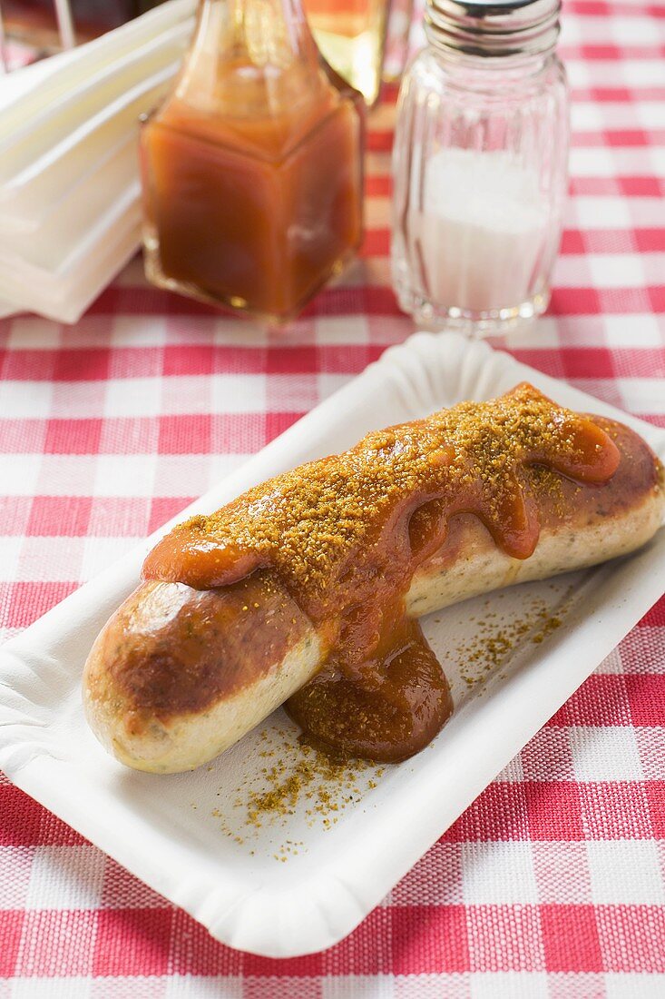 Bratwurst mit Ketchup und Curry auf Pappteller