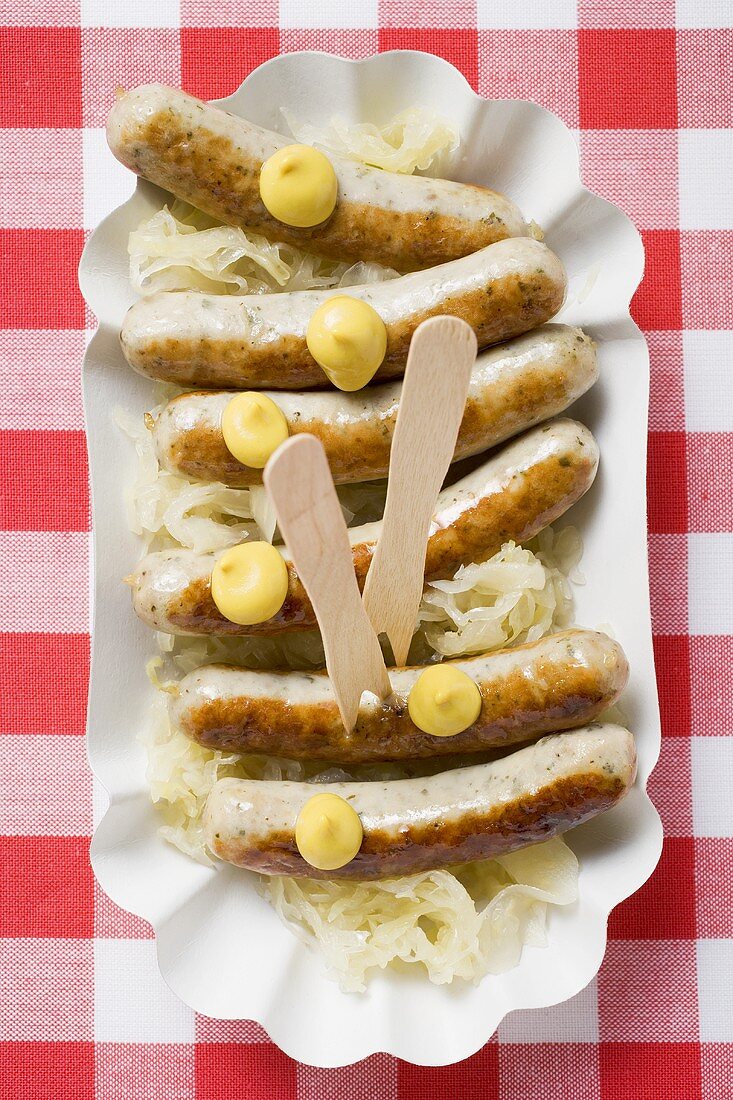 Sausages and sauerkraut with mustard in paper dish