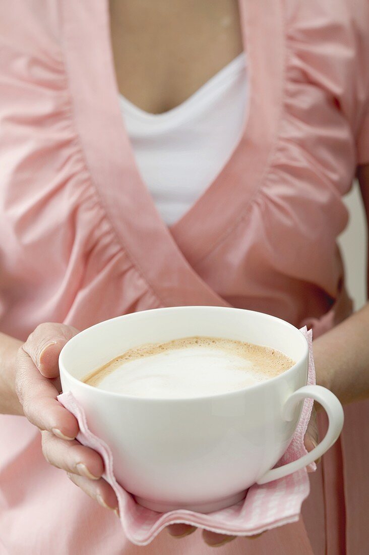 Frau hält grosse Tasse Milchkaffee
