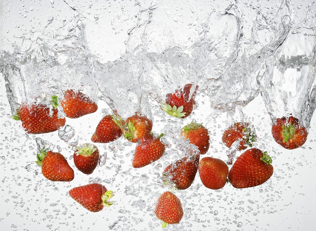 Viele Erdbeeren fallen ins Wasser