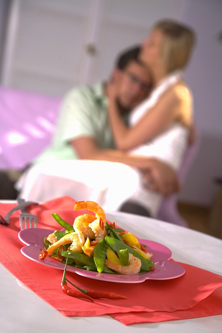 Prawns with mangetout, young lovers in background