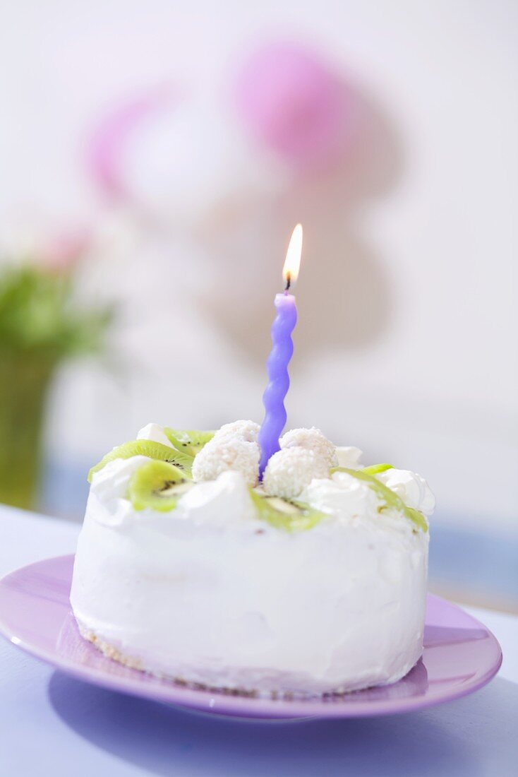 Kleine Kokos-Kiwi-Torte mit einer Kerze