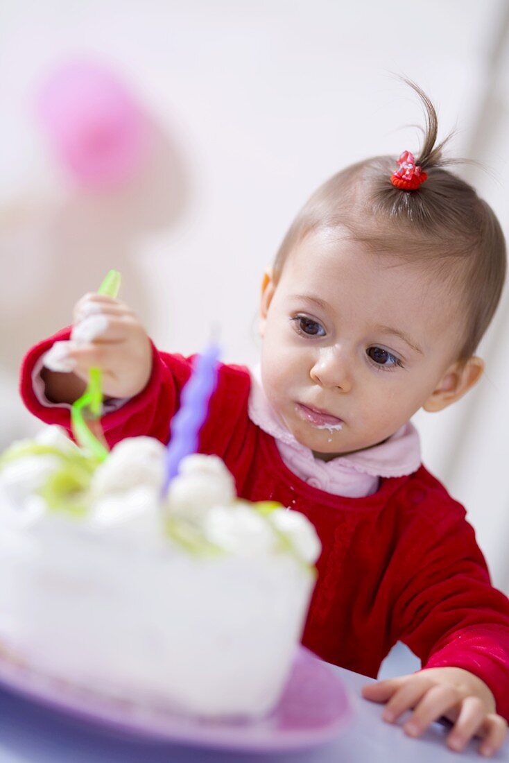 Kleines Mädchen isst Kokos-Kiwi-Torte zum Geburtstag