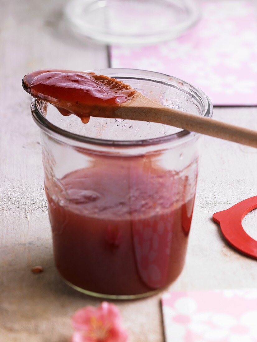 Jam in jar and on wooden spoon