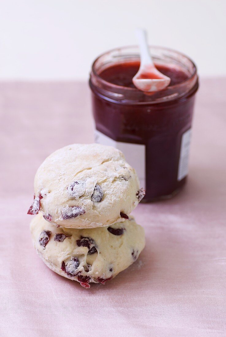 Zwei Cranberryscones und Glas Erdbeermarmelade