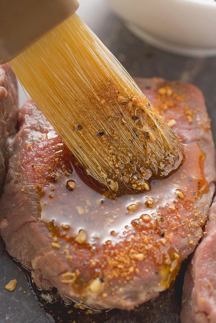 Brushing beef fillet with spicy marinade