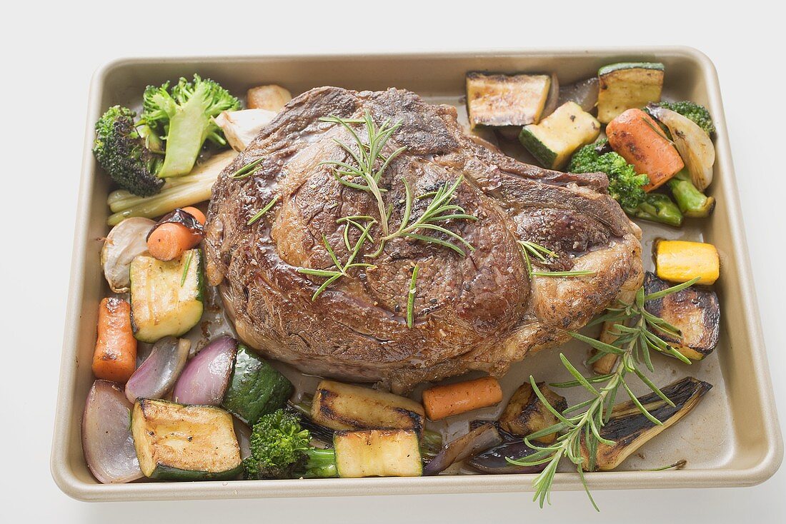 Beef steak with roasted vegetables on baking tray