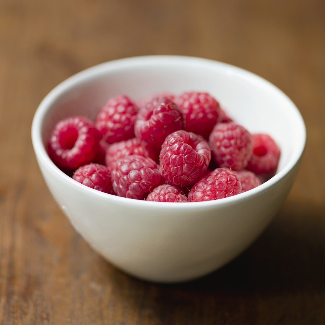 Fresh raspberries in a small ceramic bowl