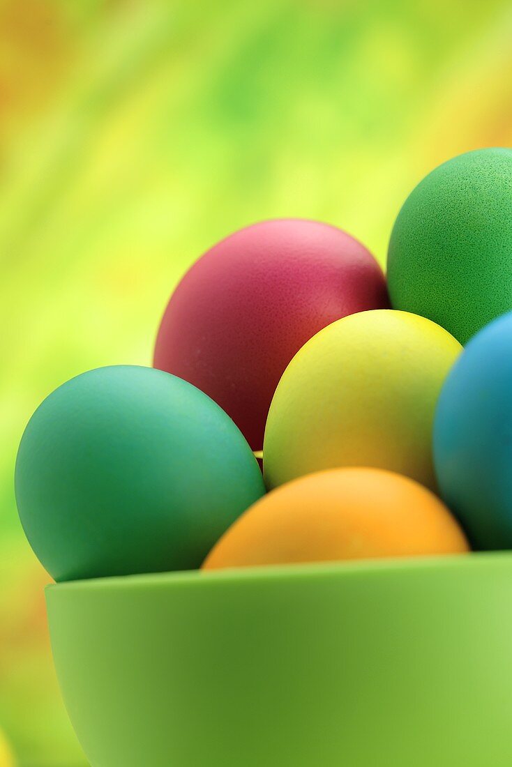 Coloured eggs in green bowl