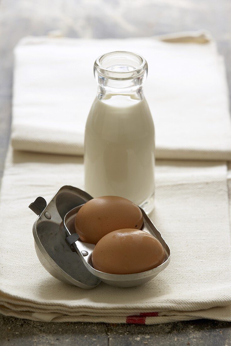 Zwei Eier und Flasche Milch auf Geschirrtuch