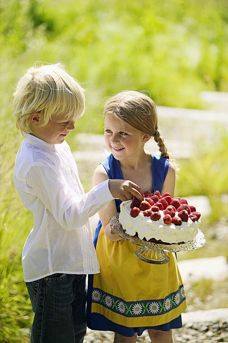 Boy and girl with strawberry cake