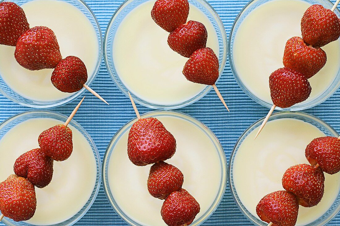 White strawberry soup with skewered strawberries
