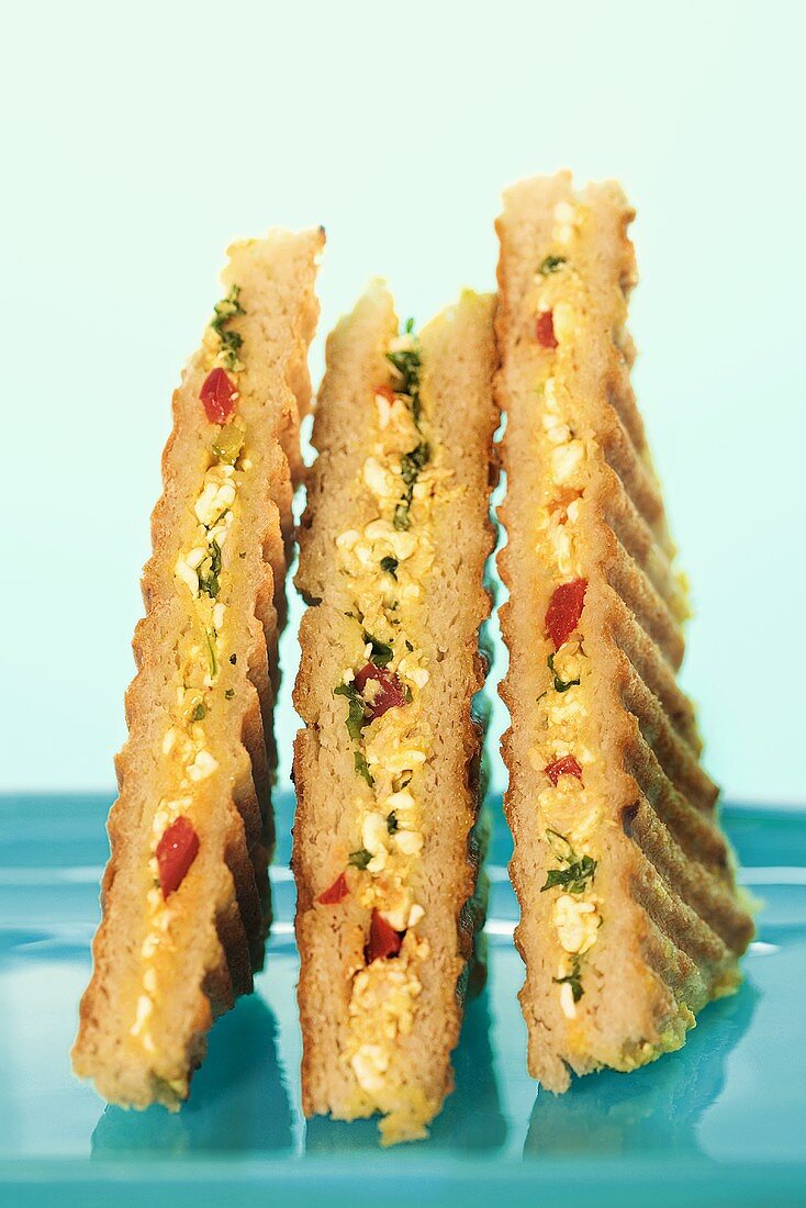 Drei Sandwichecken gefüllt mit Hüttenkäse und Mangochutney