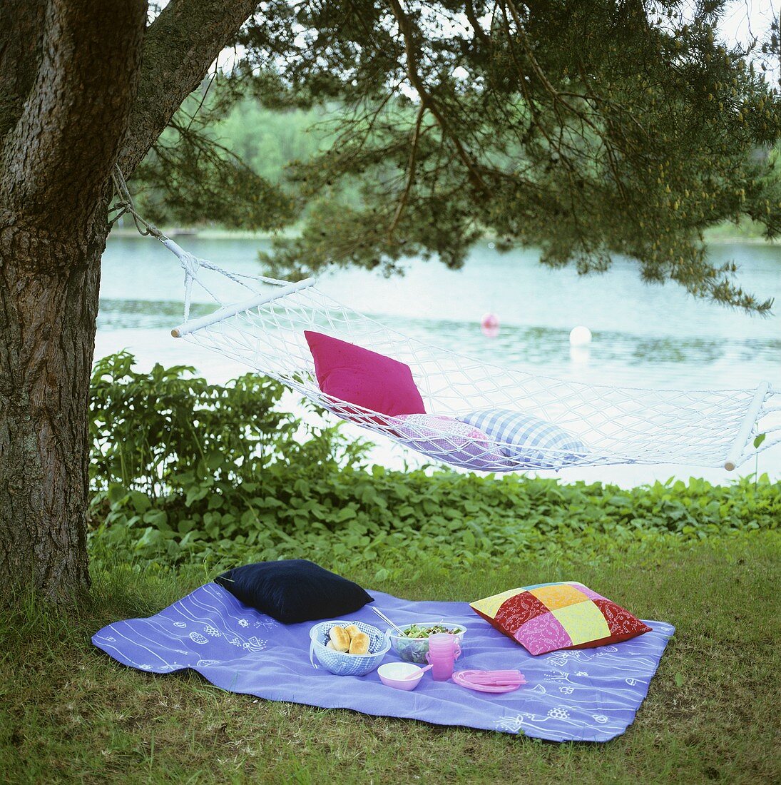 Picnic with salad and rolls by water