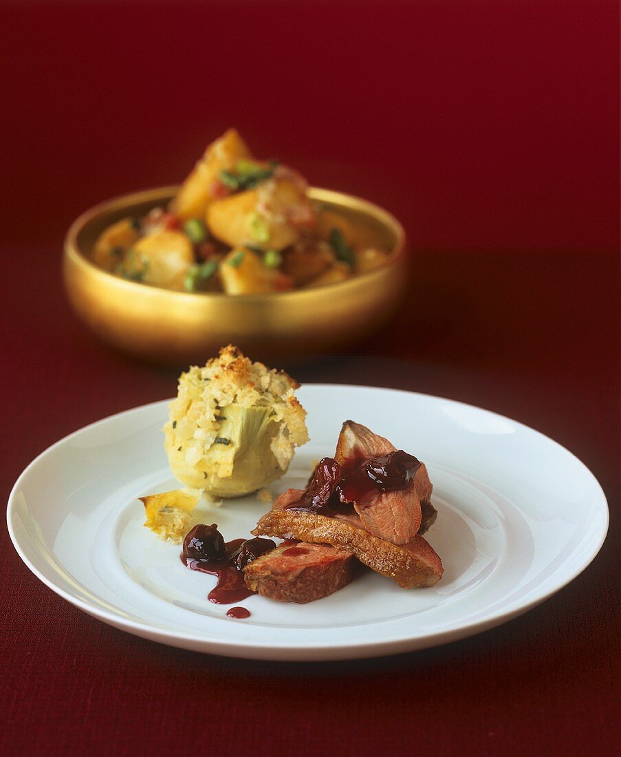 Duck with cherry sauce and artichoke with gratin topping