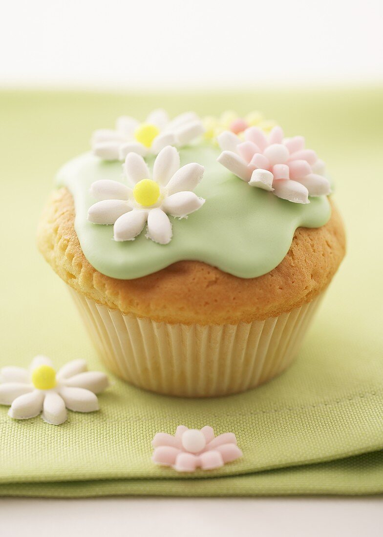 Muffin with green icing and sugar flowers