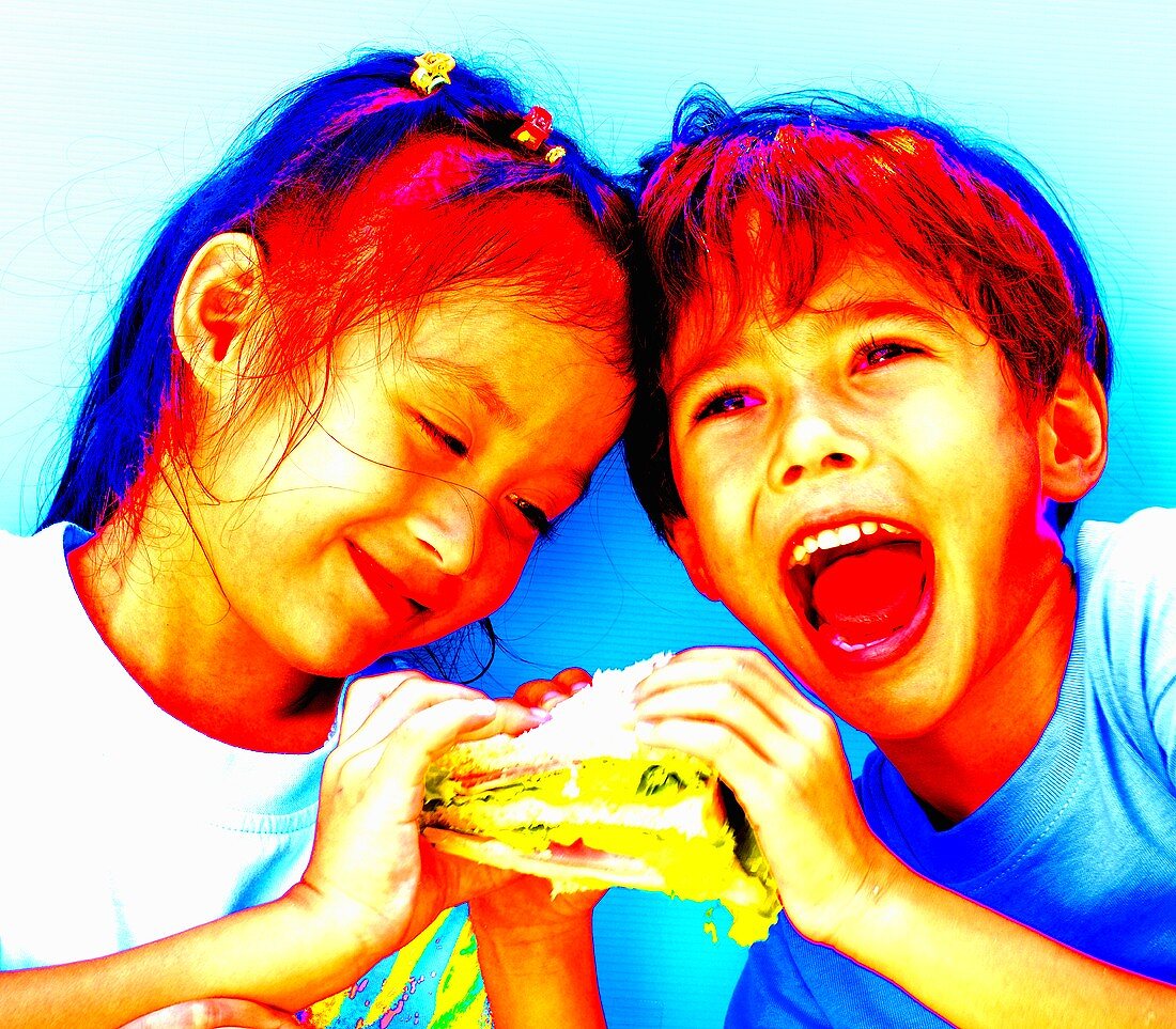 Two children eating one sandwich