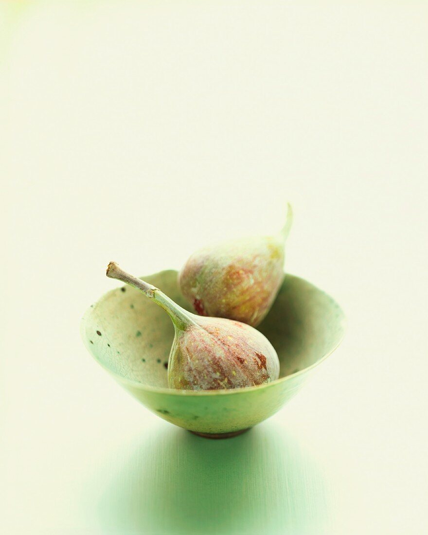 Two figs in a small bowl