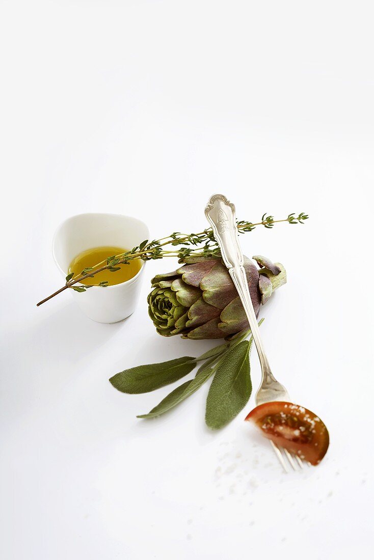 Stillleben mit Artischocke, Kräutern und Olivenöl