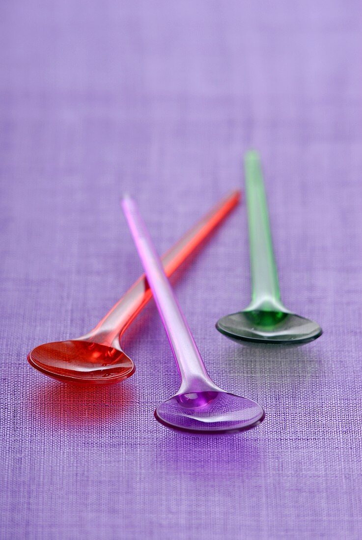 Three coloured plastic spoons