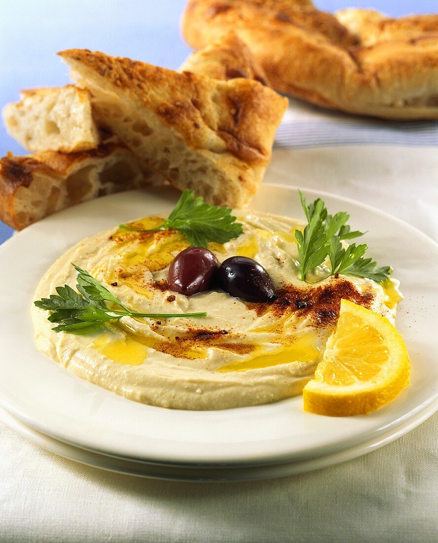 Hummus (Kichererbsendip) im Teller mit Fladenbrot