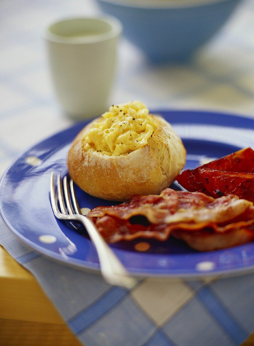 Rühreier im Brötchen mit Frühstücksspeck und Tomate