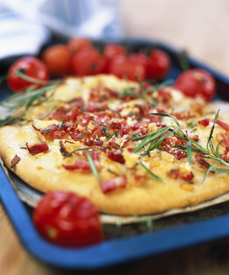 Pizza with cherry tomatoes, rosemary and diced bacon