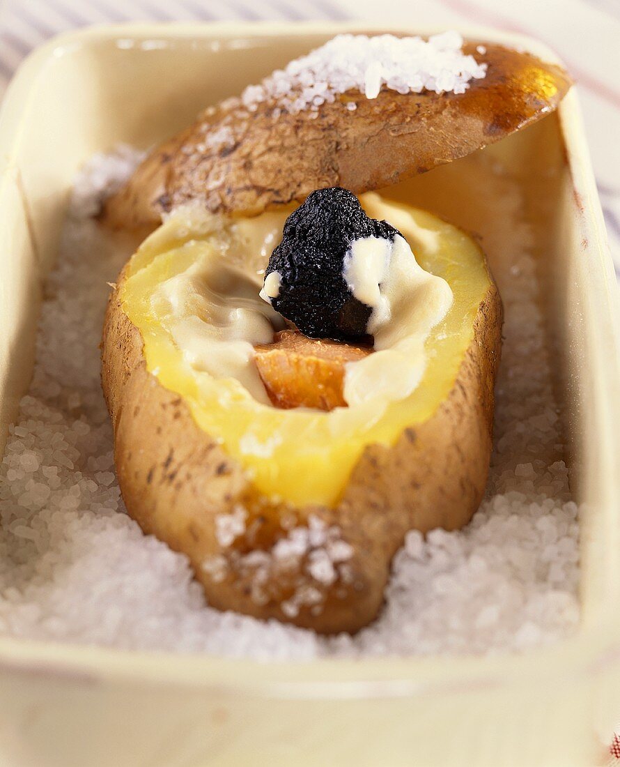 A baked potato in salt, filled with truffle and cheese