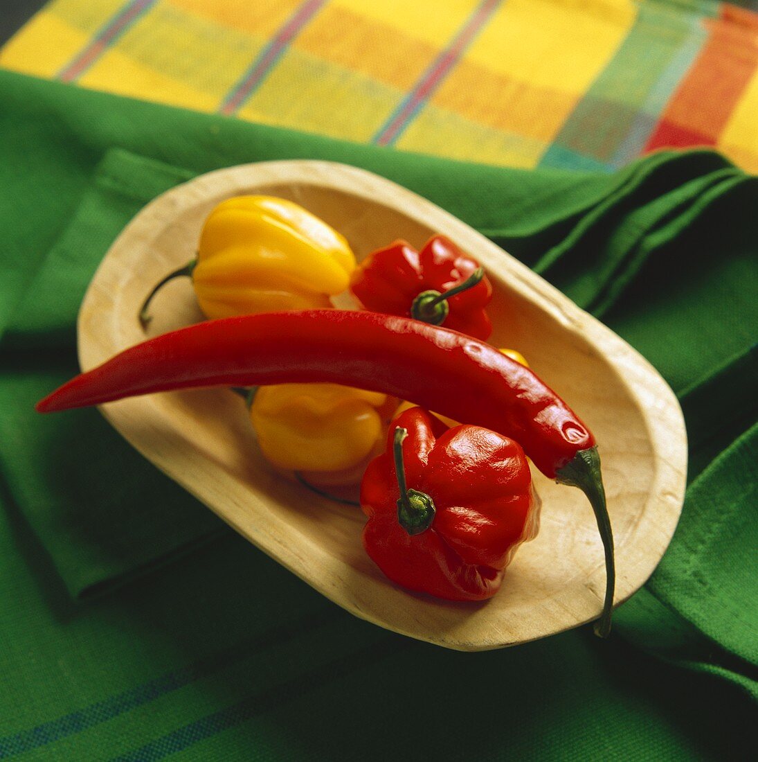 A red chili & 'Chinese lantern' chilies in a wooden bowl