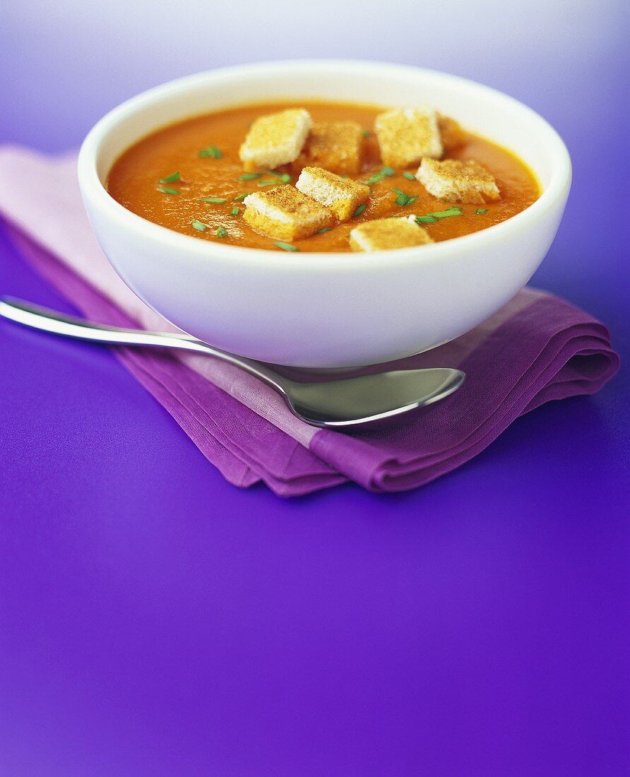 Creamed tomato soup with croutons on a napkin