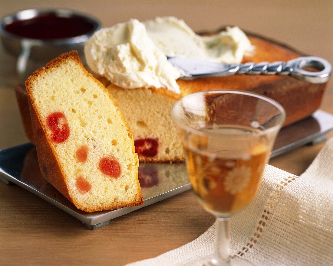 Kuchen mit Kirschen, Sahne und Likör im Vordergrund