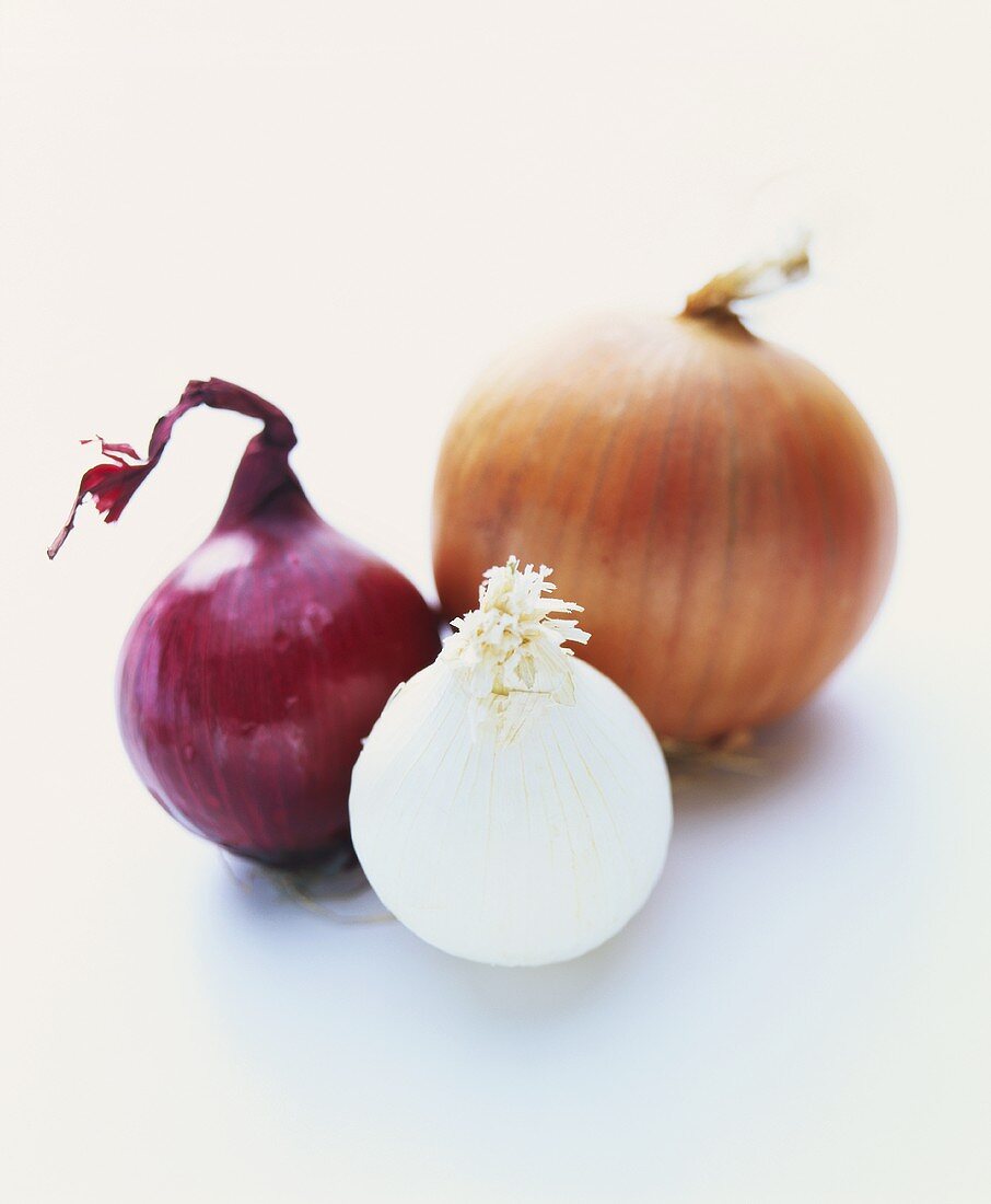 Eine rote, eine weiße und eine braune Zwiebel