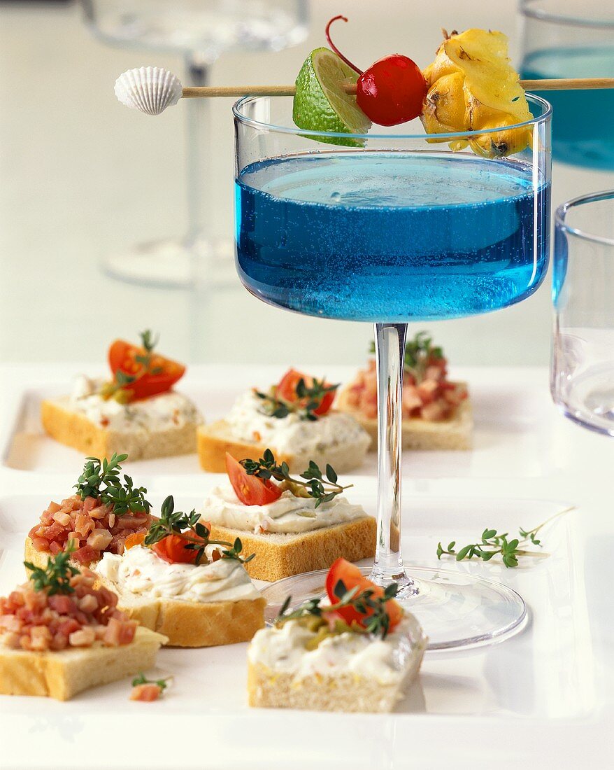 Blue Curacao cocktail as aperitif with snacks