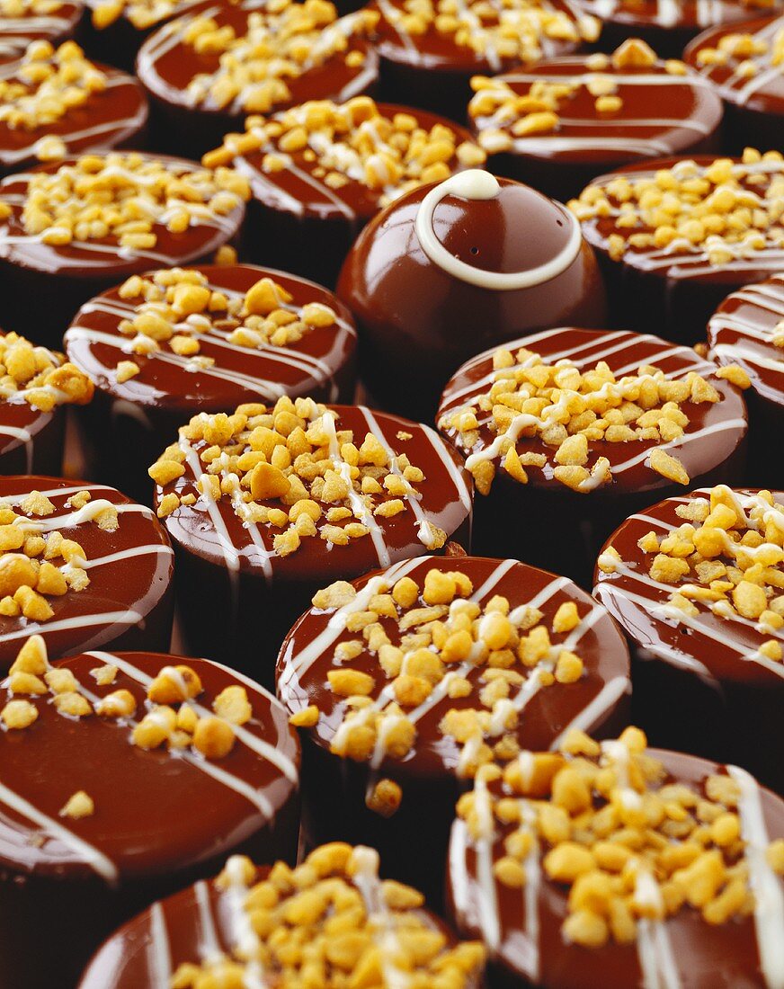 Chocolates sprinkled with nuts (filling the picture)