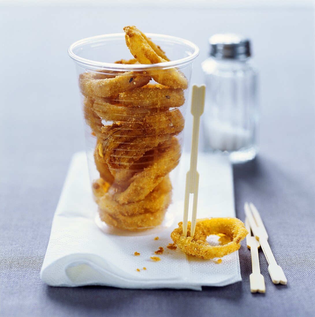 Deep-fried onion rings in plastic beaker