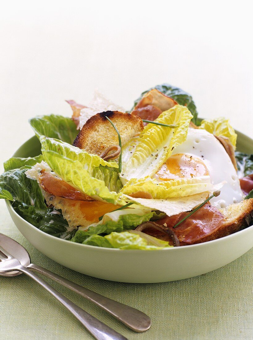 Caesar salad with bacon and fried egg