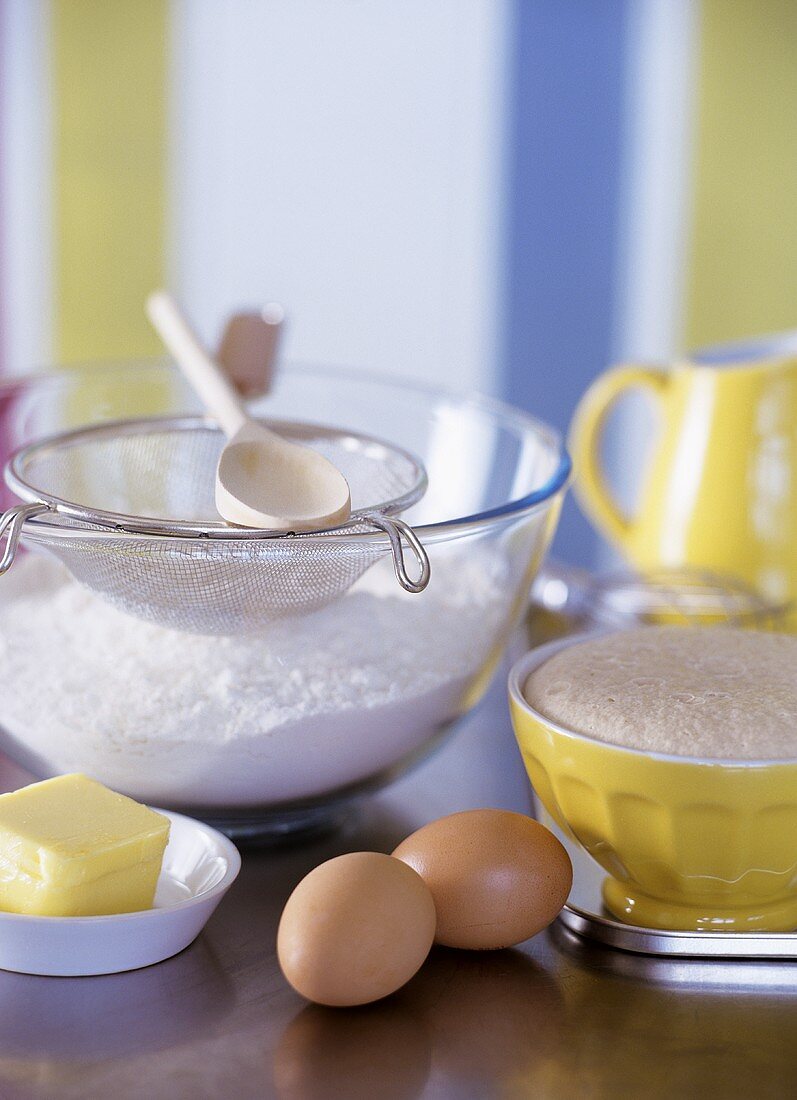 Baking still life with flour, eggs, butter & baking utensils