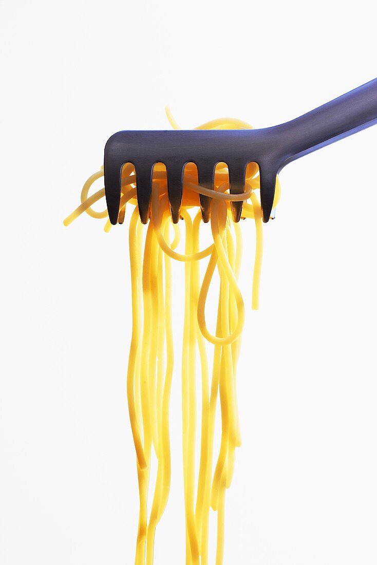 Cooked spaghetti in pasta tongs