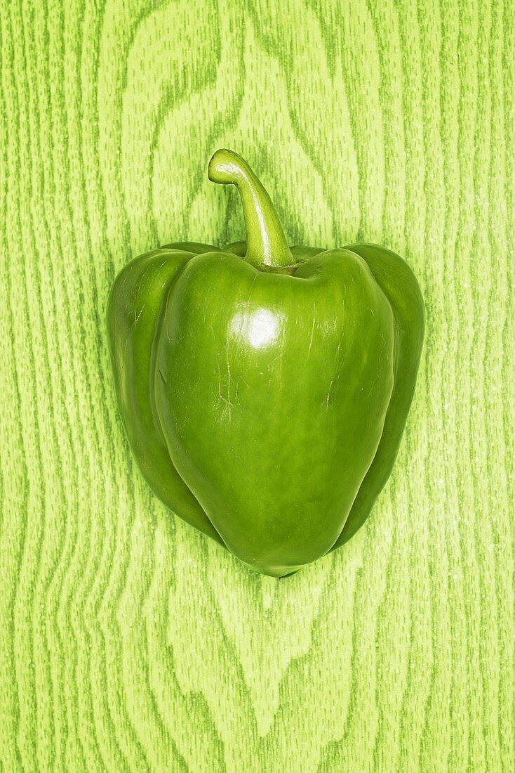 Green pepper against green wooden background