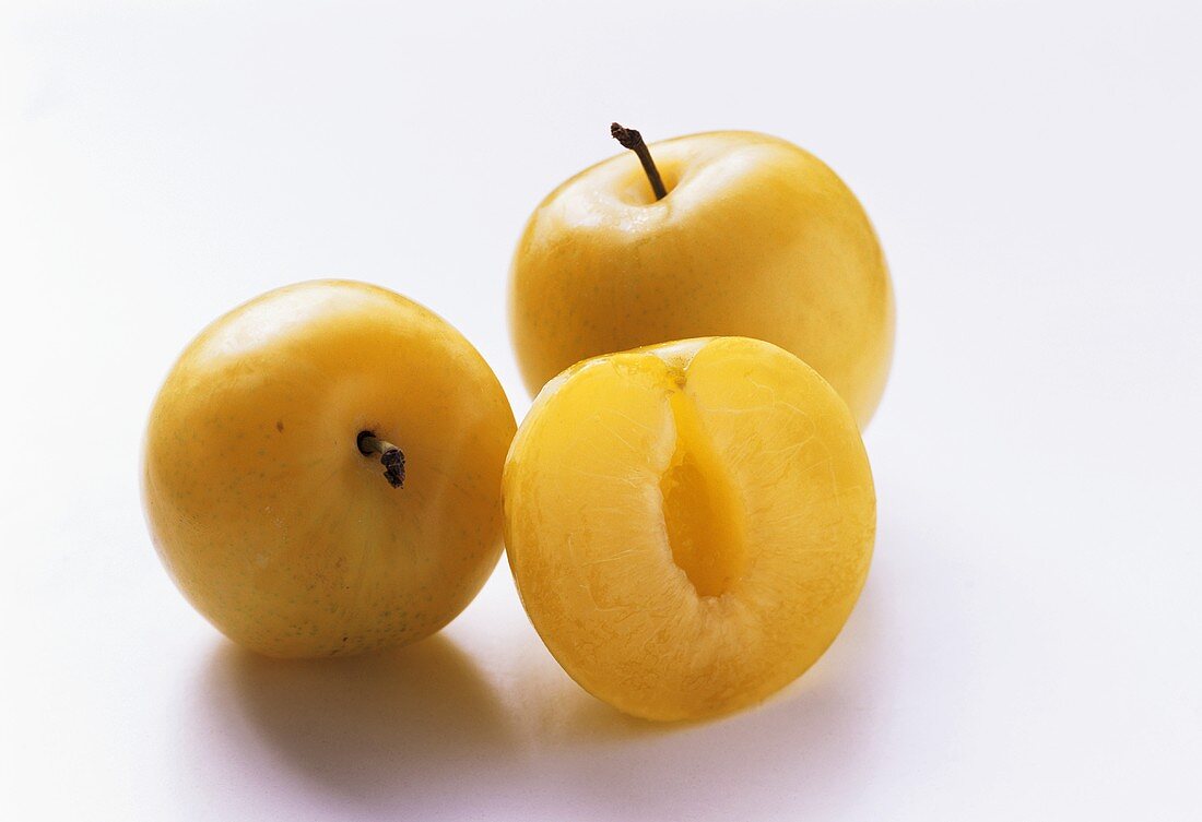Two Whole Yellow Plums with One Half