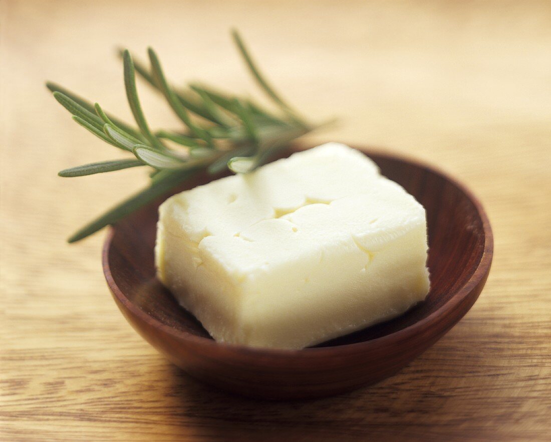 Fresh Butter in a Wooden Bowl with Rosemary
